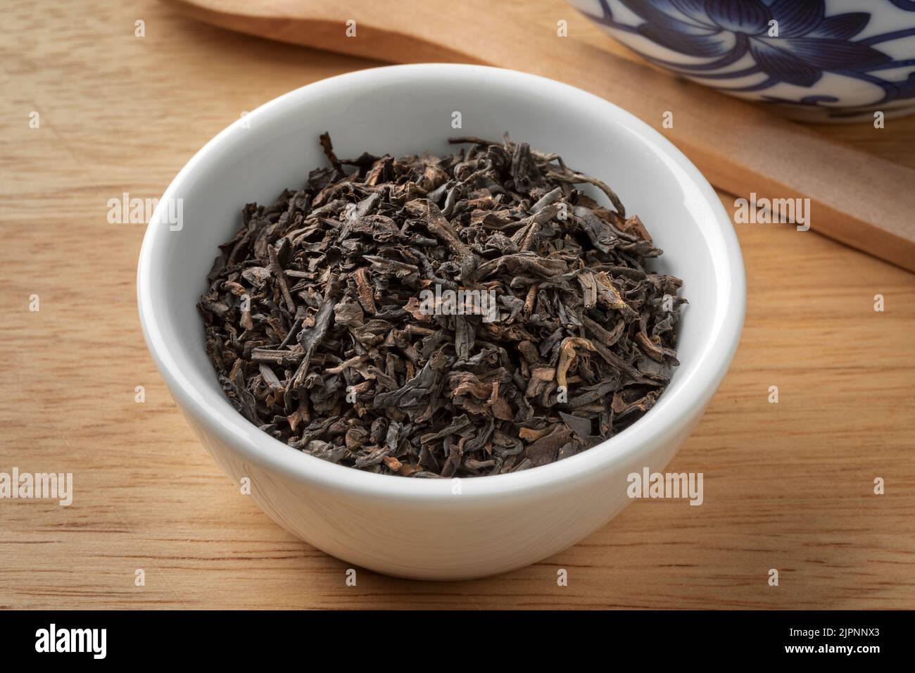 Ciotola con cinese pu EHR foglie di tè essiccato da vicino Foto Stock