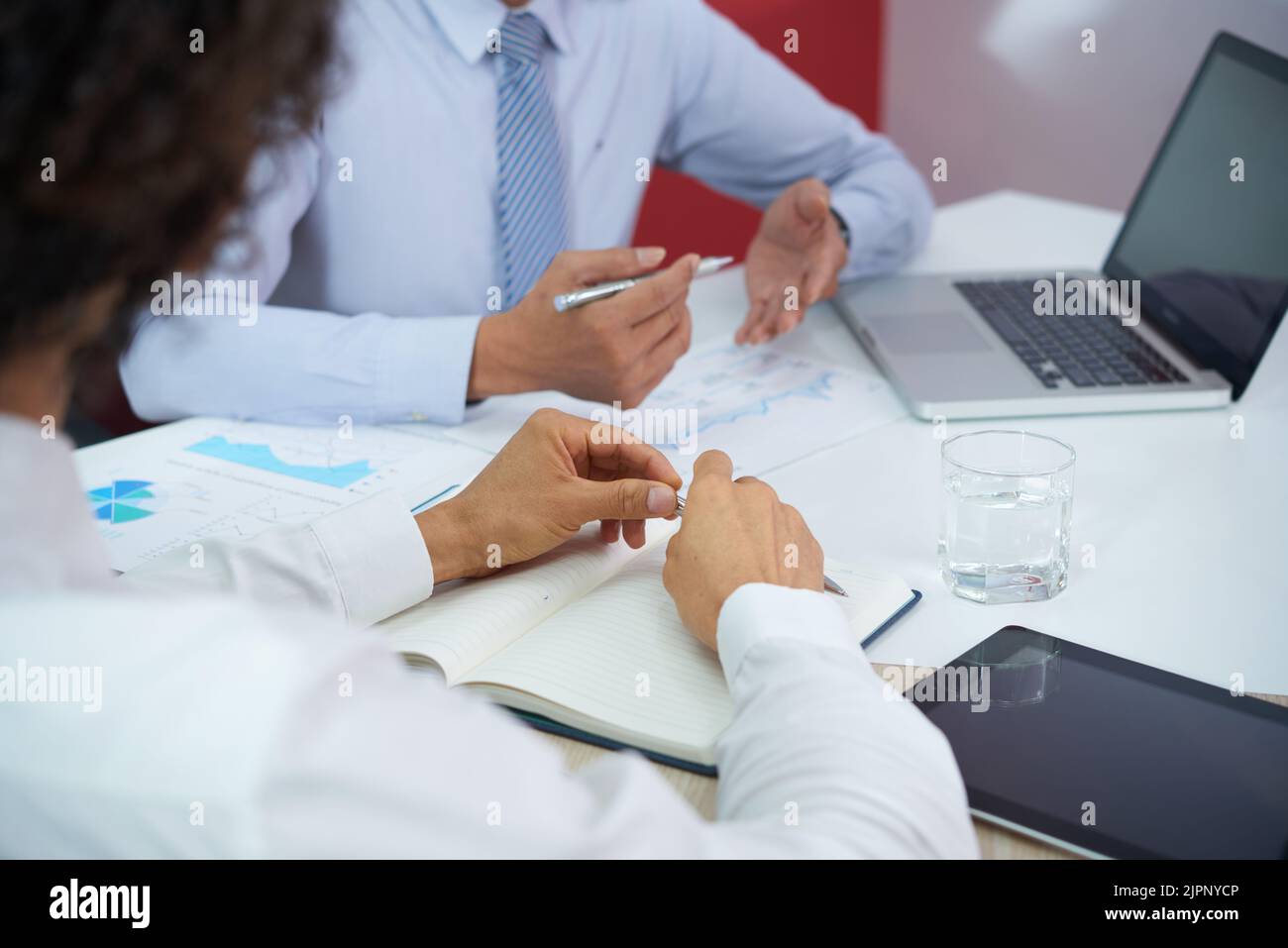 Immagine ravvicinata delle persone che lavorano per affari che discutono della situazione sul mercato durante la riunione Foto Stock