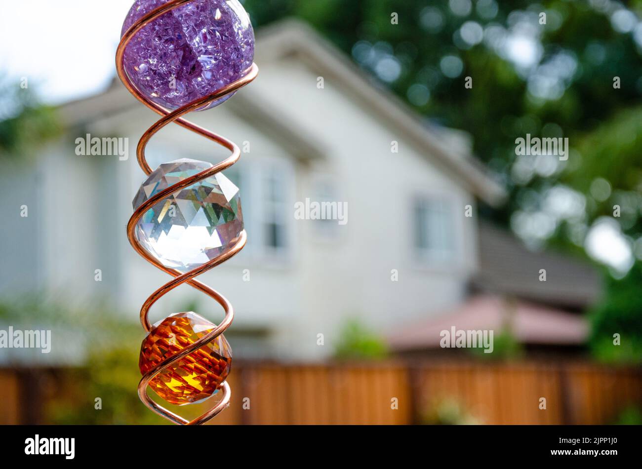 Un poco profondo fuoco di una decorazione del giardino costituito da sfere colorate e spirali metalliche intrecciate. Foto Stock