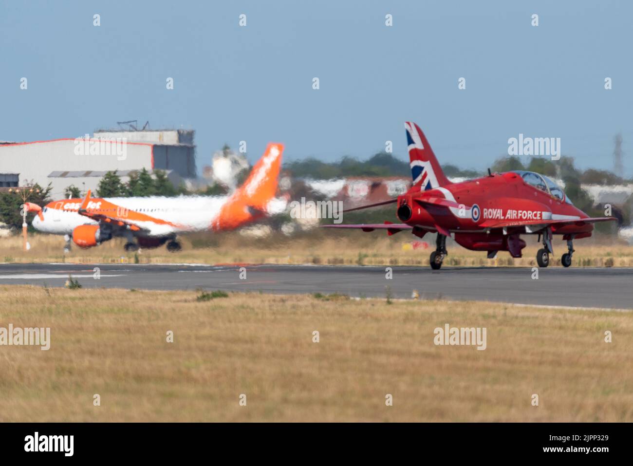 Aeroporto Southend di Londra, Essex, Regno Unito. 19th ago, 2022. Le frecce rosse della RAF stanno utilizzando l’aeroporto civile per operare da per gli spettacoli aerei di questo fine settimana a Eastbourne e Folkestone. Le frecce rosse sono arrivate questa sera, arrivando nella loro famosa formazione di frecce prima di rompersi a terra. EasyJet partenza per Faro tenendo come Red Arrow jet taxi fuori pista Foto Stock