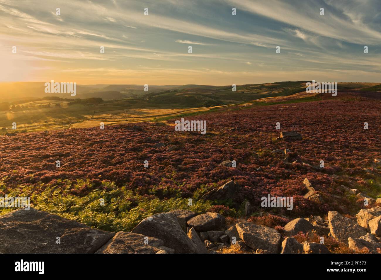 La luce serale si avvicina al tramonto guardando fuori da Owler Tor, nel Parco Nazionale del Peak District Foto Stock