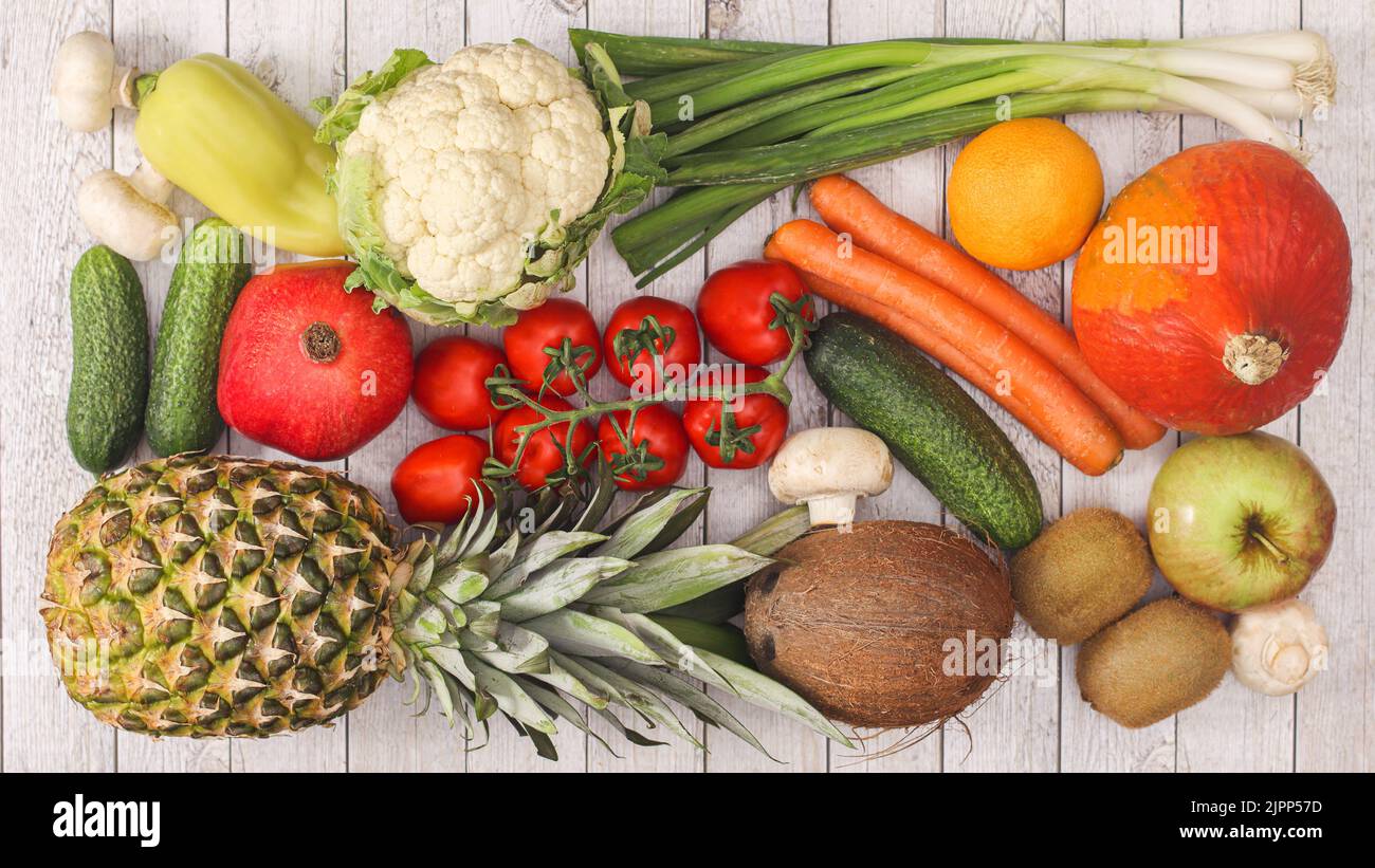 tavola di legno con frutta e disposizione di verdure. Piatto laici concetto di cibo sano Foto Stock