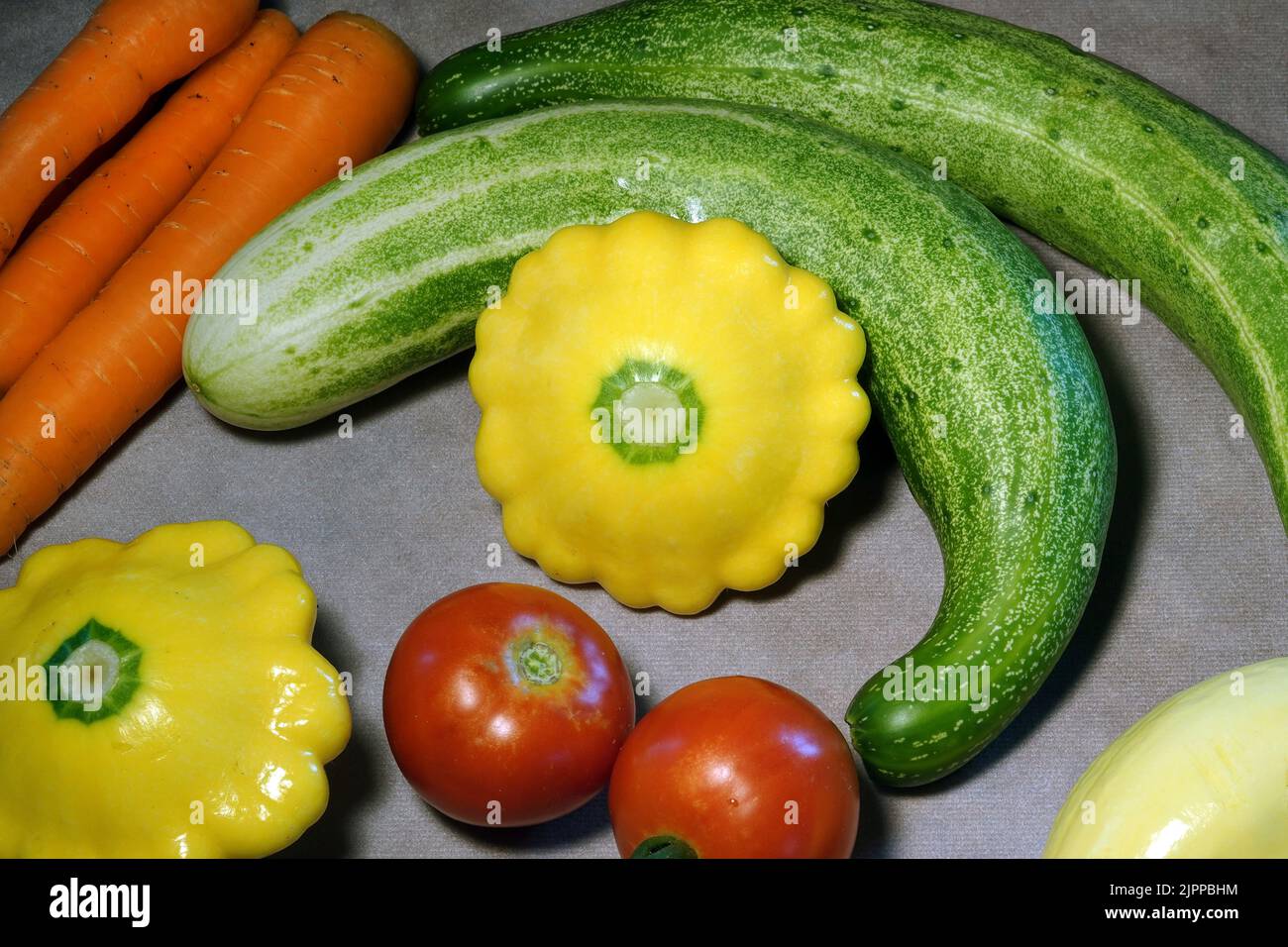 Una varietà di verdure fresche, direttamente da un giardino di casa, tra cui cetrioli, carote e zucca. Foto Stock