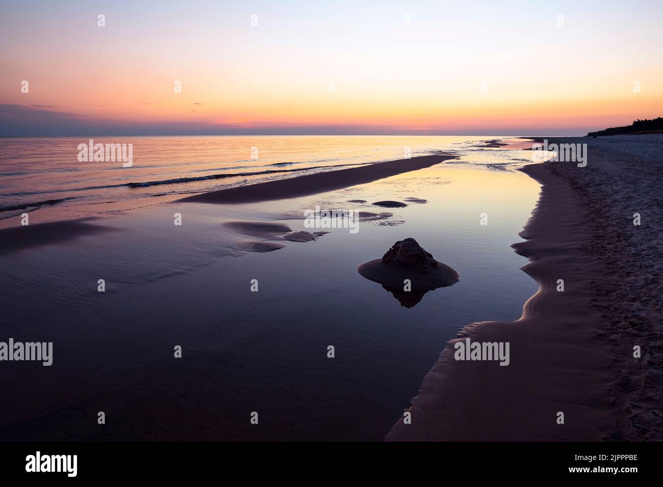 Mare Baltico vuoto spiaggia paesaggio orizzonte arancione sopra l'acqua. Panorama marino con cielo all'alba. Bella alba sul mare, riflessi pastello in t Foto Stock