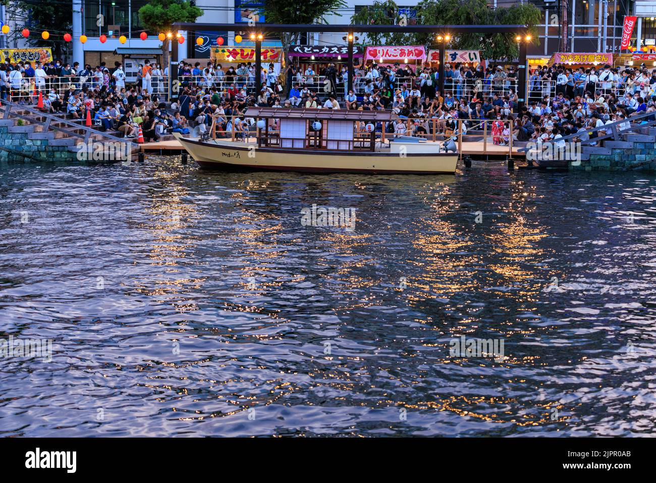 Tokushima, Giappone - 12 agosto 2022: Una piccola barca e una folla attendono lo spettacolo notturno al festival di Awaodori Foto Stock