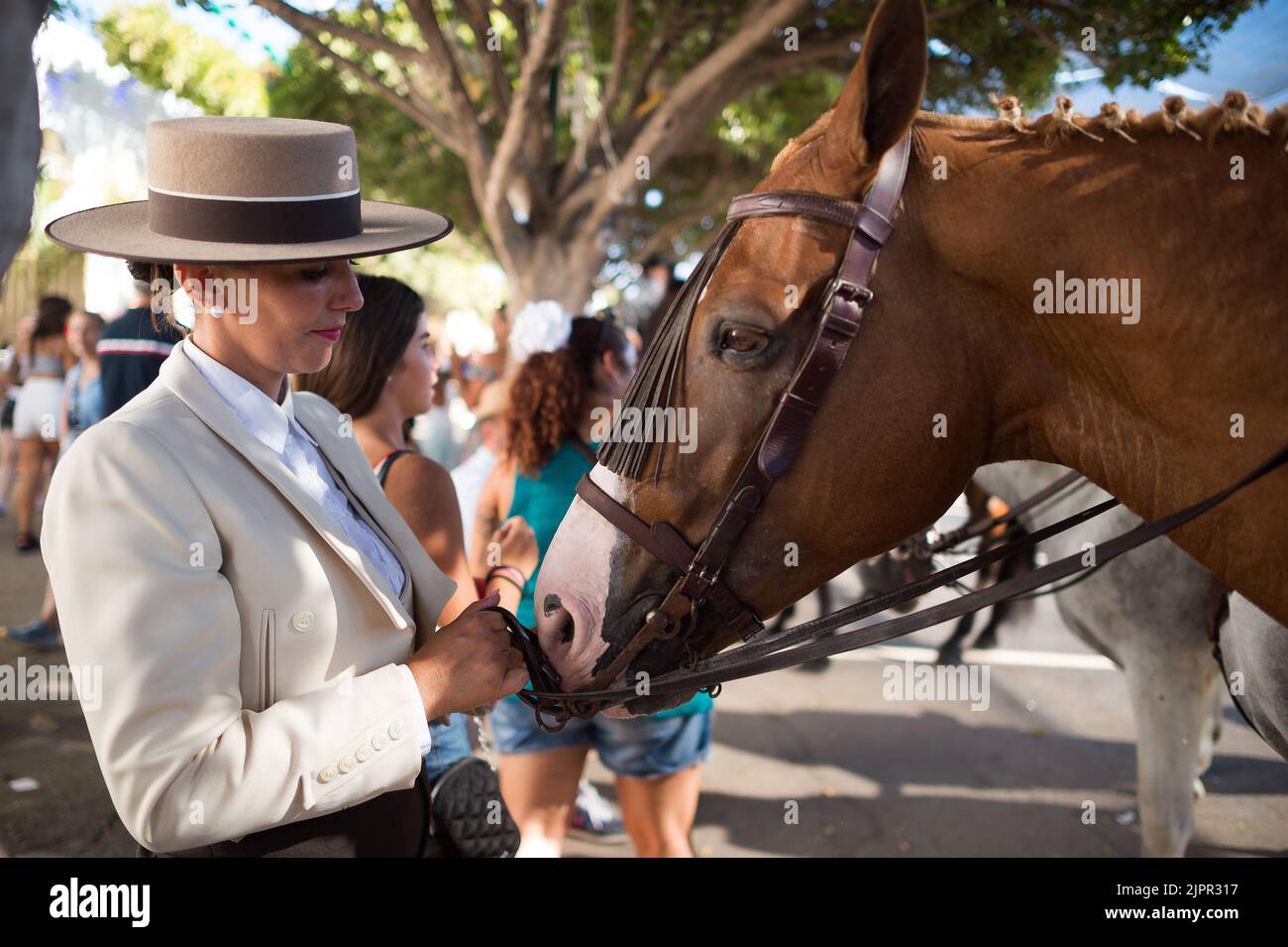 Malaga, Spagna. 19th ago, 2022. Una donna di cavalli è vista guardando il suo cavallo come partecipa alla fiera di Malaga 2022 alla fiera 'Cortijo de Torres' recinzione. Dopo due anni di cancellazione a causa della pandemia di coronavirus, migliaia di persone si riuniscono nelle strade principali della città per partecipare alla Fiera di Malaga in un'atmosfera festosa. Tra una settimana, migliaia di turisti e abitanti del luogo potranno assistere a concerti, balli di flamenco per le strade e altre attività come la fiera della corrida o gli spettacoli di cavalli. (Credit Image: © Jesus Merida/SOPA Images via ZUMA Press Wire) Foto Stock