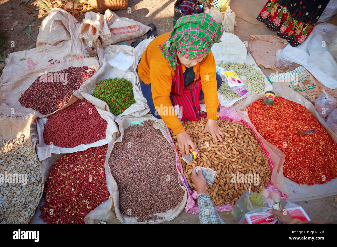 Birmano locale che vende spezie e frutta secca in uno stand presso il Phaung Daw OO Market, Inle Lake, Myanmar. Foto Stock