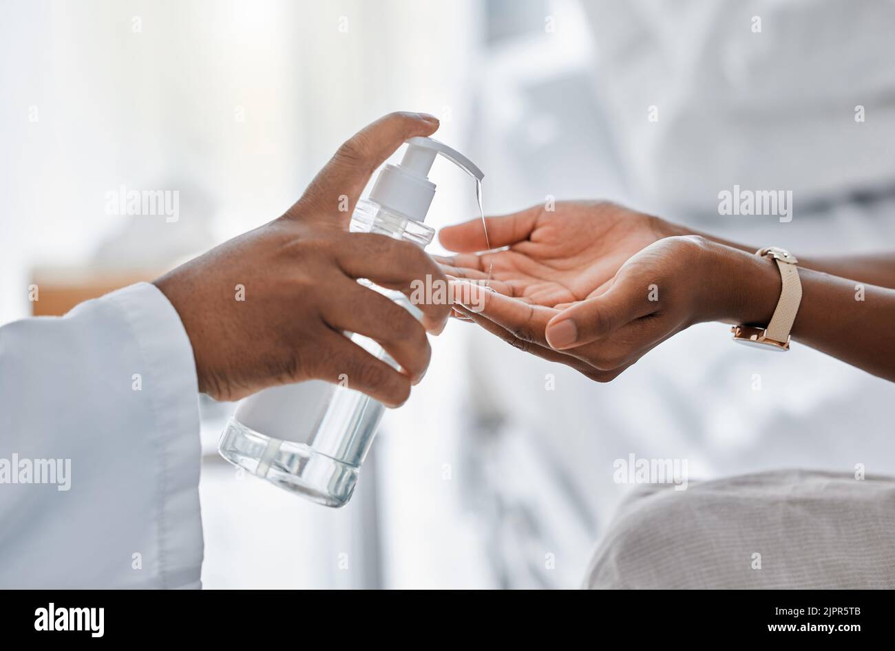 Medico che dà paziente disinfettante per le mani per la protezione, l'igiene e la disinfezione dei batteri in pandemia covida, protocollo e virus. Sicurezza sanitaria e. Foto Stock