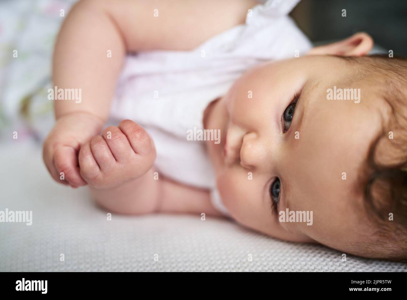 Un fascio di cuteness. Una ragazza adorabile del bambino sdraiato giù sul letto nel paese. Foto Stock