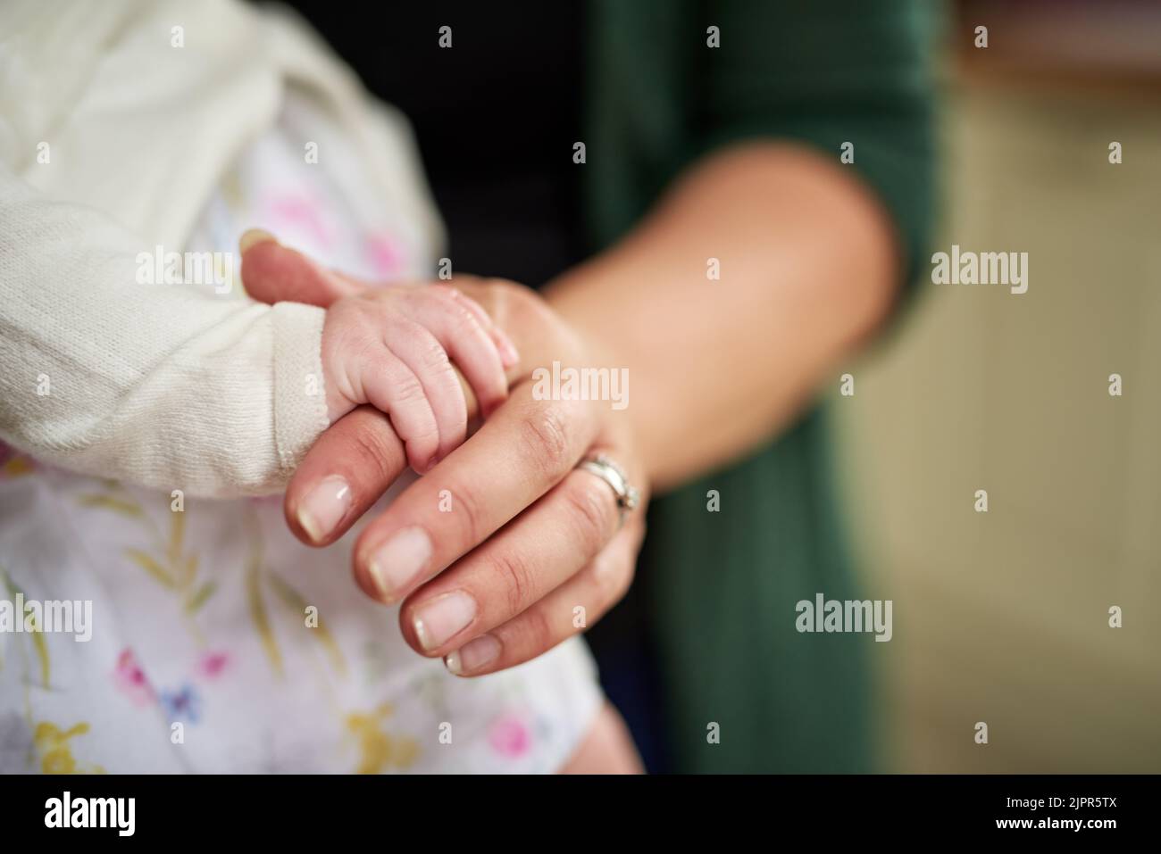 Le ceneri hanno ottenuto una stretta ferma sul cuore di Moms. Colpo di primo piano di una madre che tiene la sua piccola mano delle bambine. Foto Stock