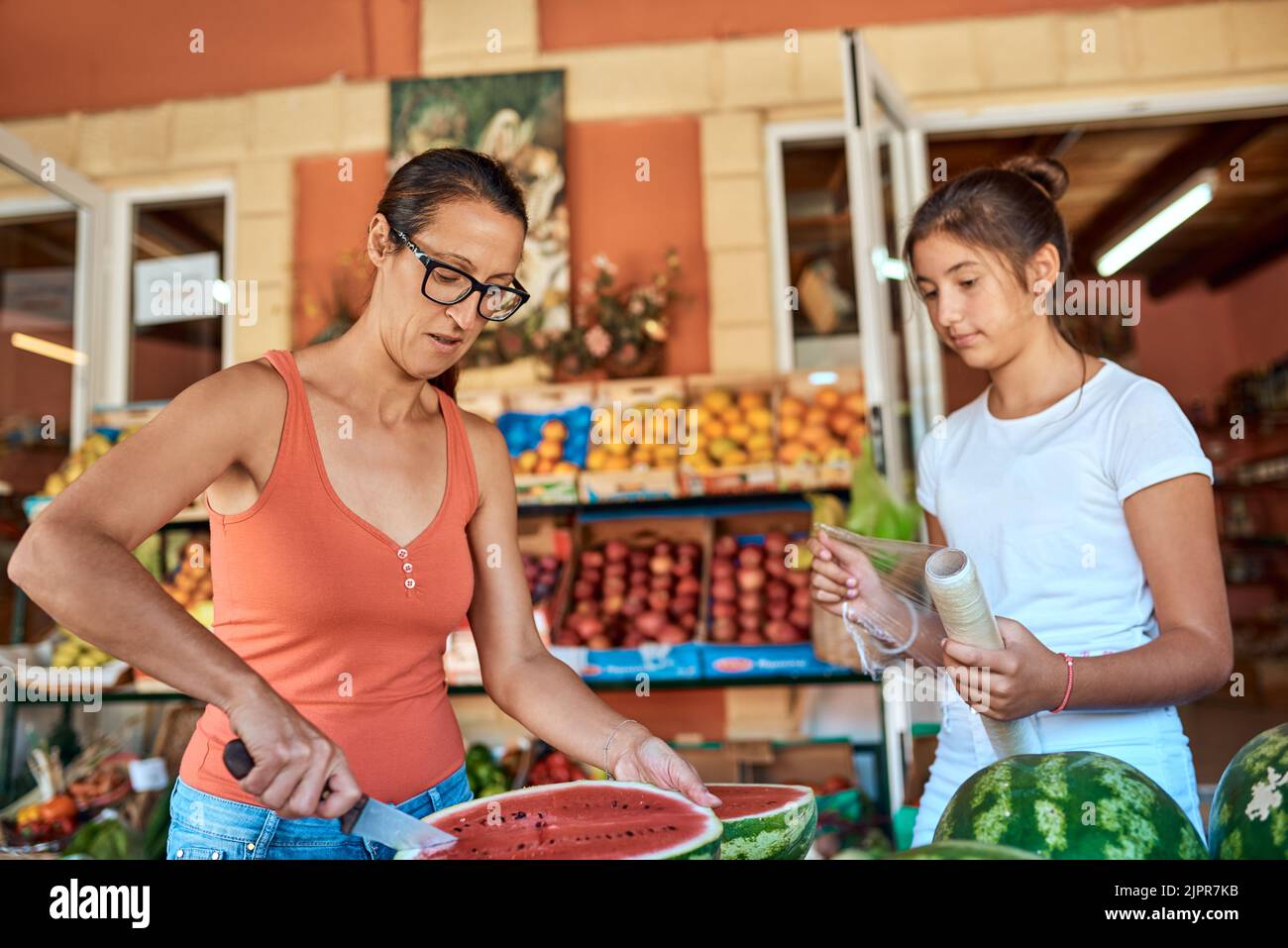 Preparare i cocomeri per la vendita. Una madre e una figlia che lavorano in una stalla di fattoria. Foto Stock
