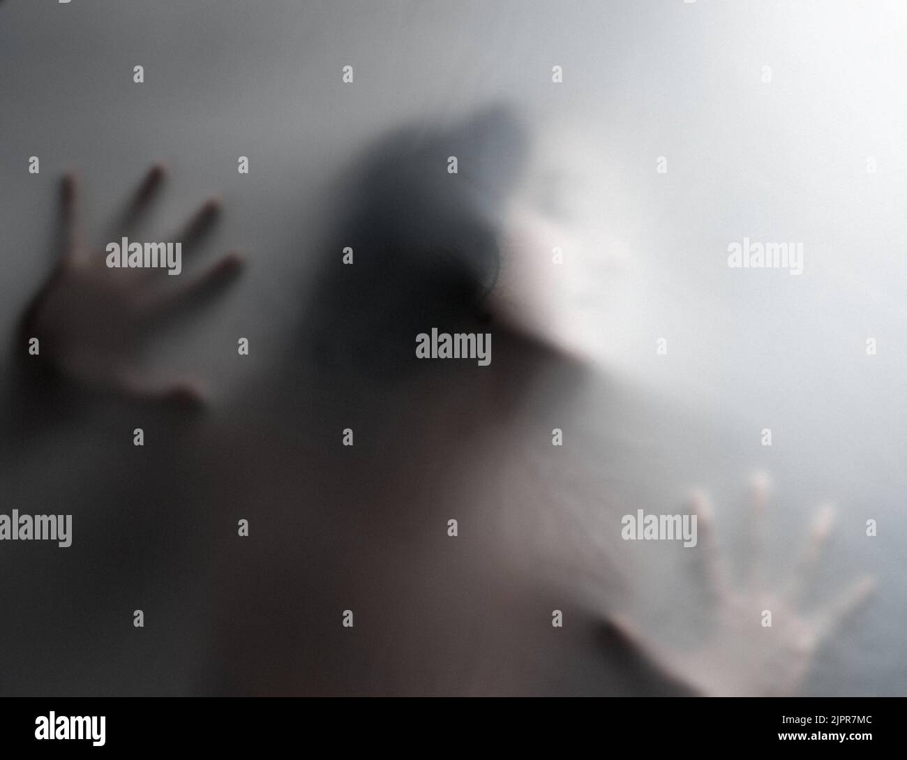 La fuga è futile: Una donna irriconoscibile intrappolata dietro un film nebuloso. Foto Stock