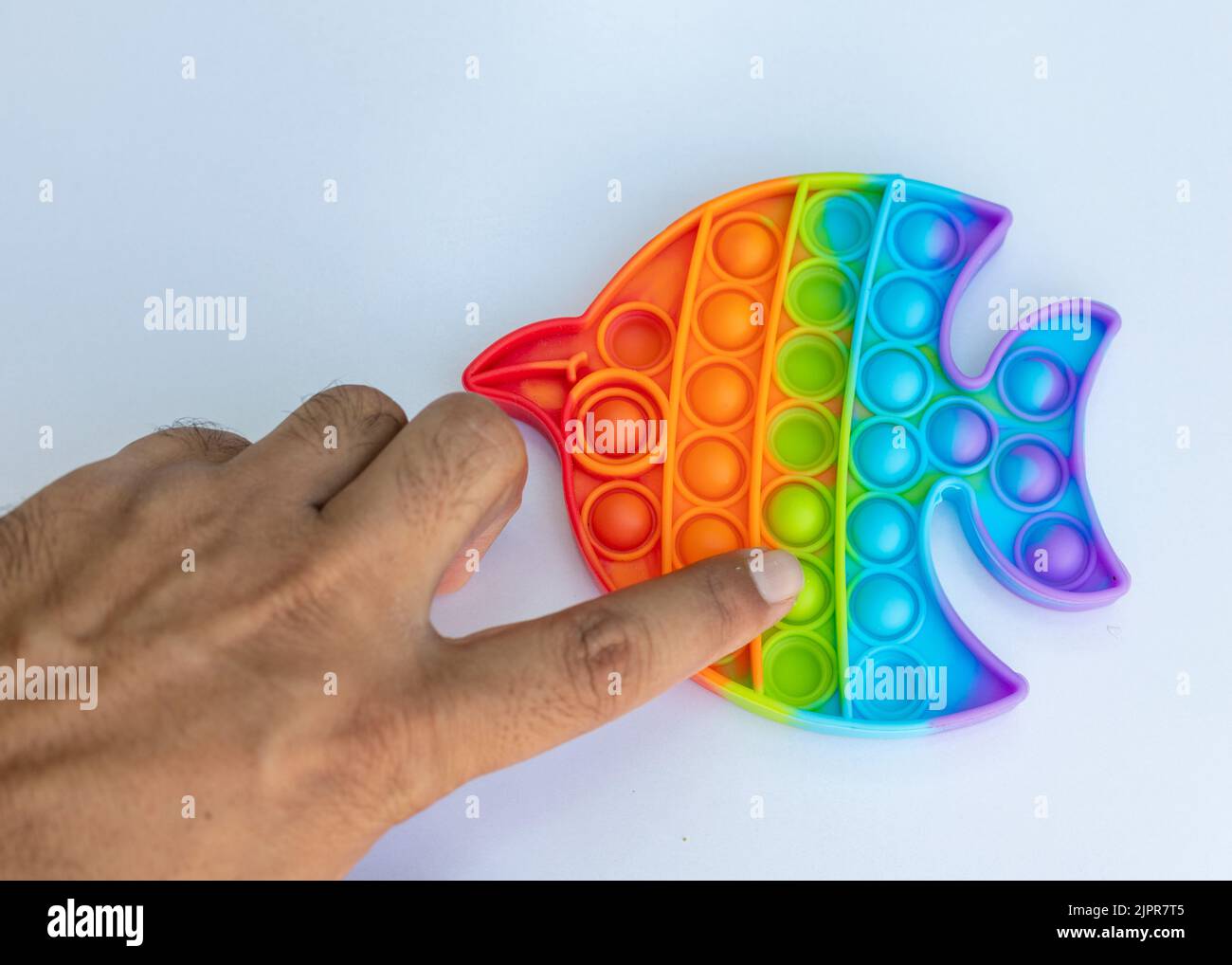 Uomo che spinge pop è bolla fidget giocattoli per l'ansia e lo stress sollievo Foto Stock