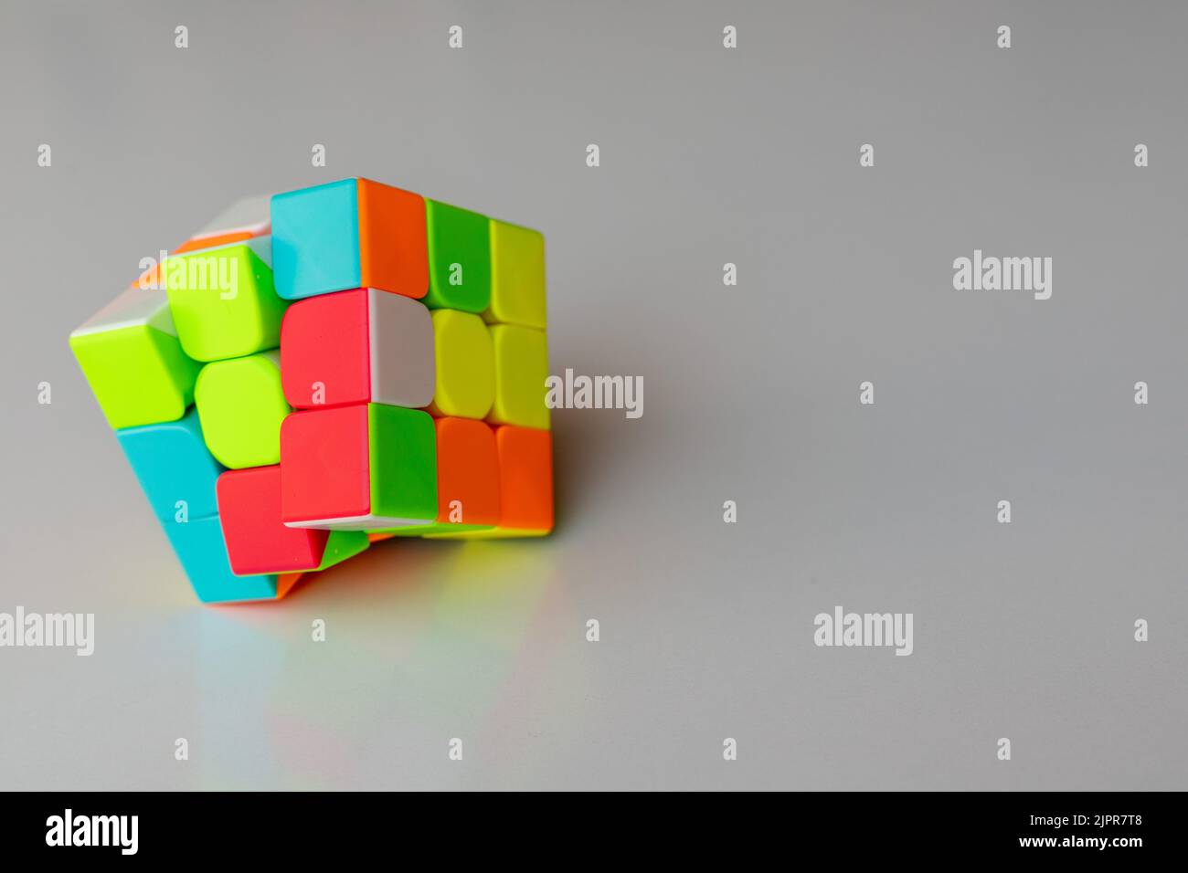 Puzzle cubo gioco su uno sfondo bianco con spazio copia e fuoco selettivo Foto Stock