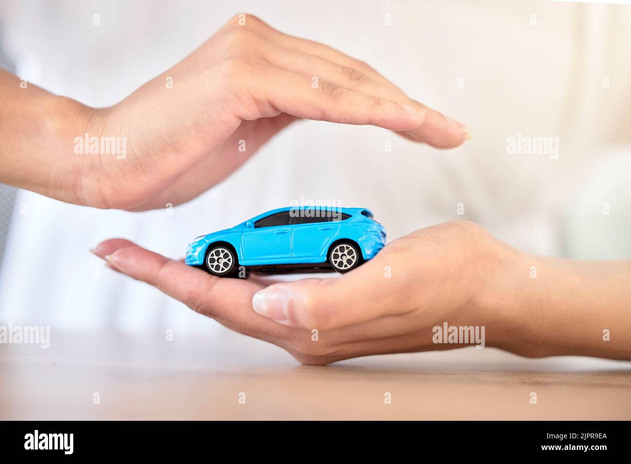 Assicurazione auto, finanza e sicurezza di viaggio modello dimensioni veicolo coperto, sicurezza e protetto dalle mani. Finanziario, automobile giocattolo e. Foto Stock