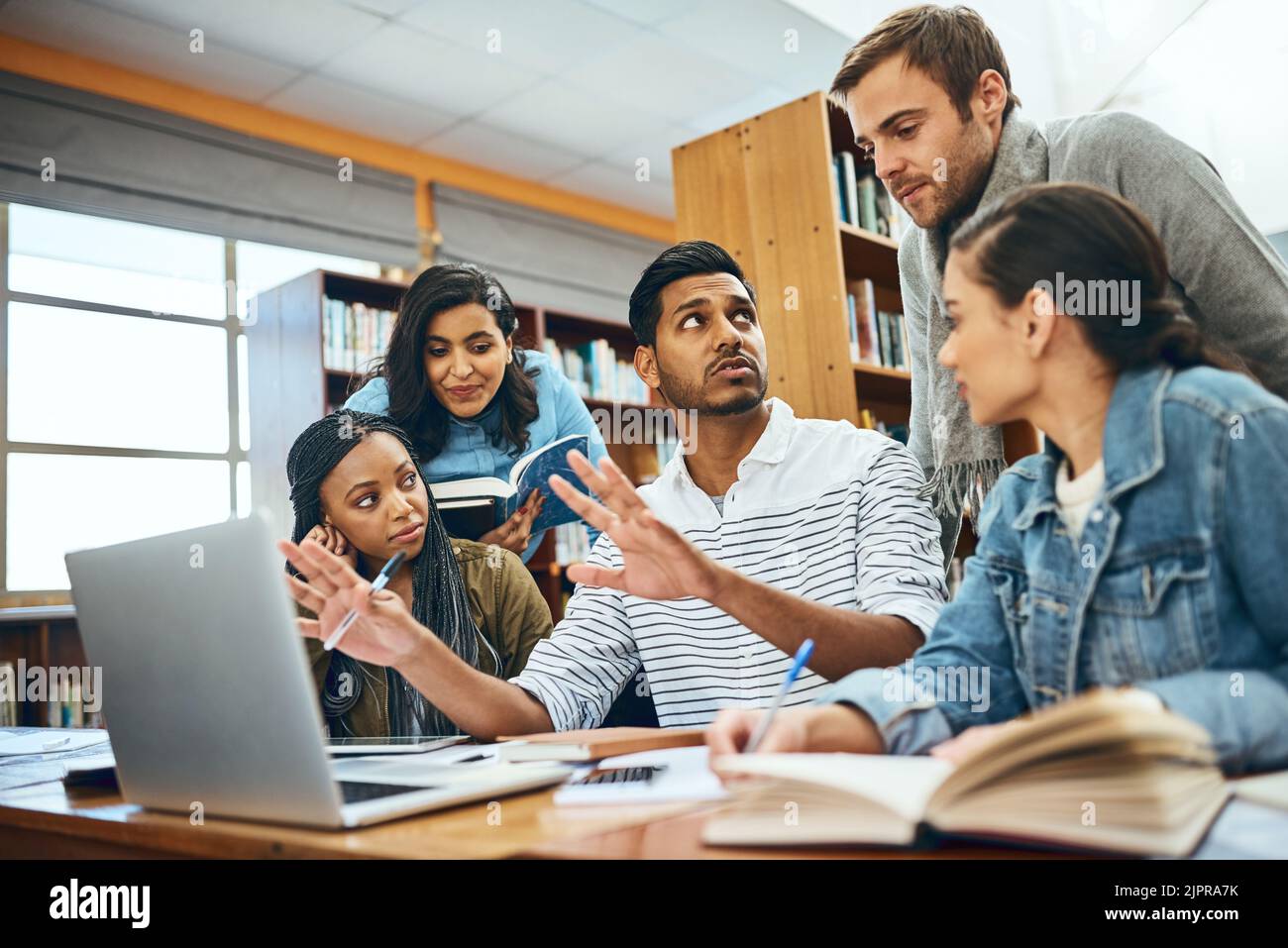 HES un grande tutor. Un gruppo di studenti universitari che studiano in biblioteca. Foto Stock