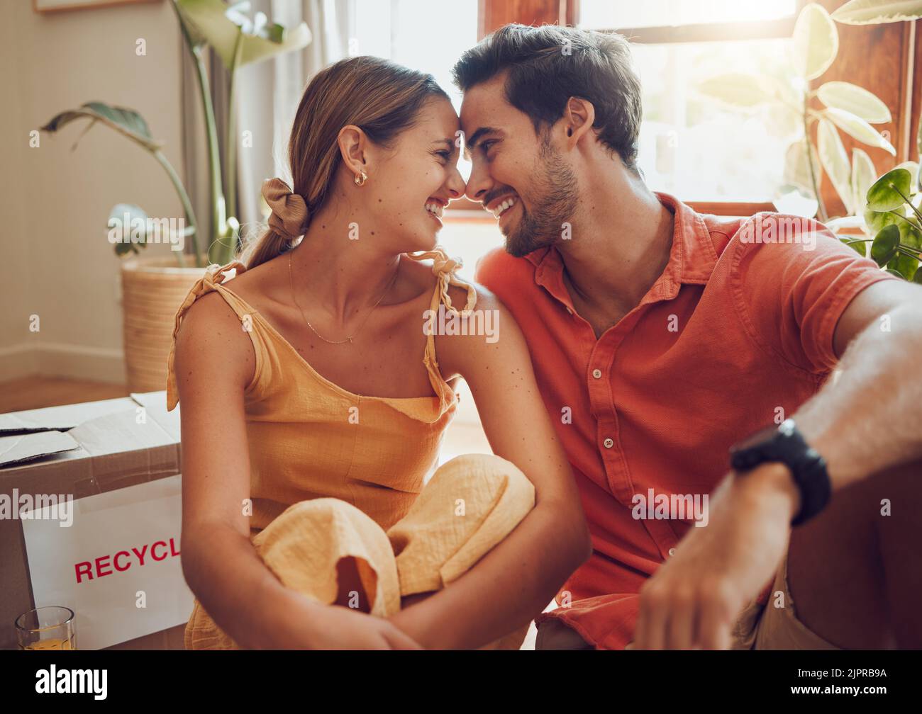 Felice e innamorato coppia seduta insieme, legame e trascorrere il tempo di qualità in un nuovo appartamento, appartamento o casa. Proprietario di casa, amore uomo e donna rilassarsi Foto Stock