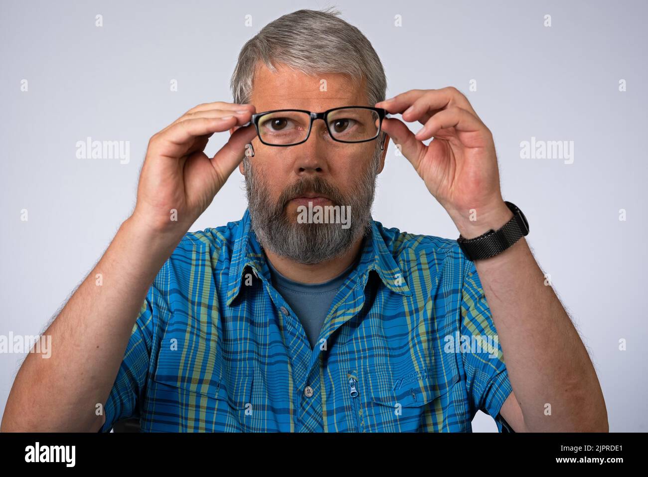 Uomo, 55 anni in studio, immagine simbolo acuità visiva, occhiali Foto Stock