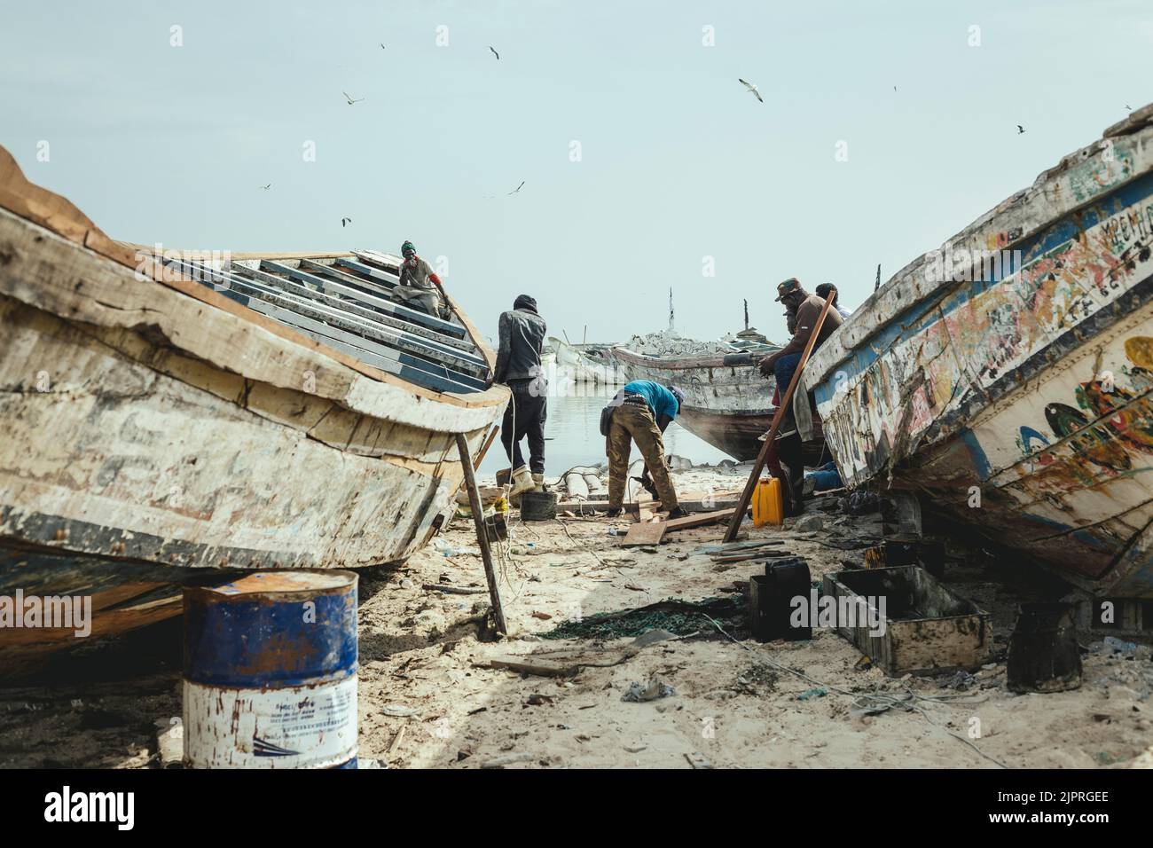 Pescatori che riparano una barca, Port de Peche traditionelle, Nouadhibou, Mauritania Foto Stock