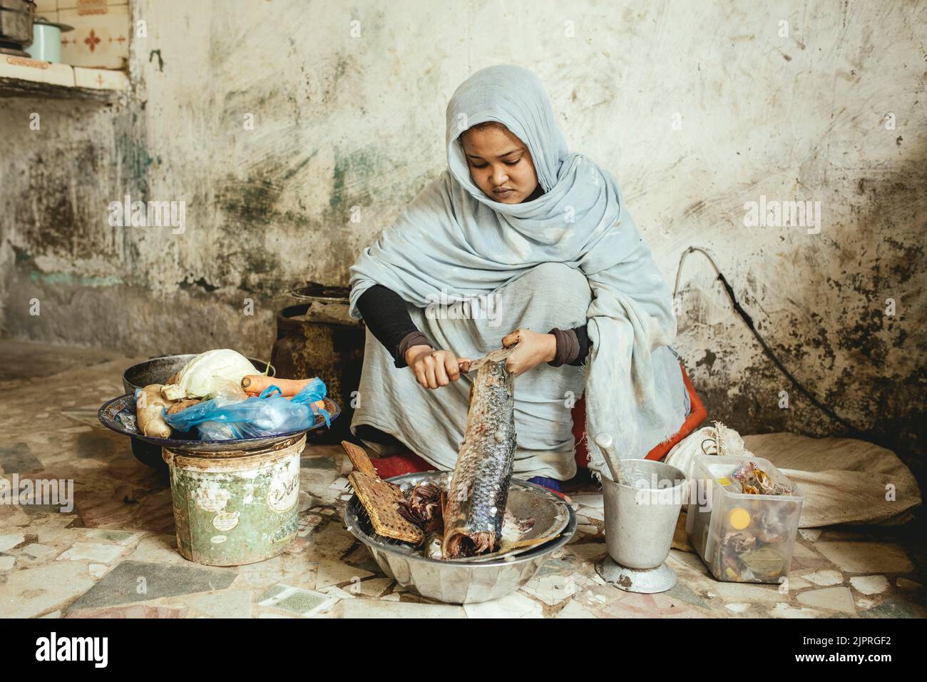 Ebeti Abidino, figlia del pescatore ben Abden che prepara cibo per la famiglia, riso con pesce, il piatto tradizionale dei pescatori e. Foto Stock