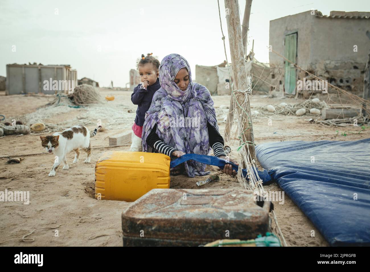 Donna che riempie acqua potabile in un barattolo, Nouamghar, Mauritania Foto Stock