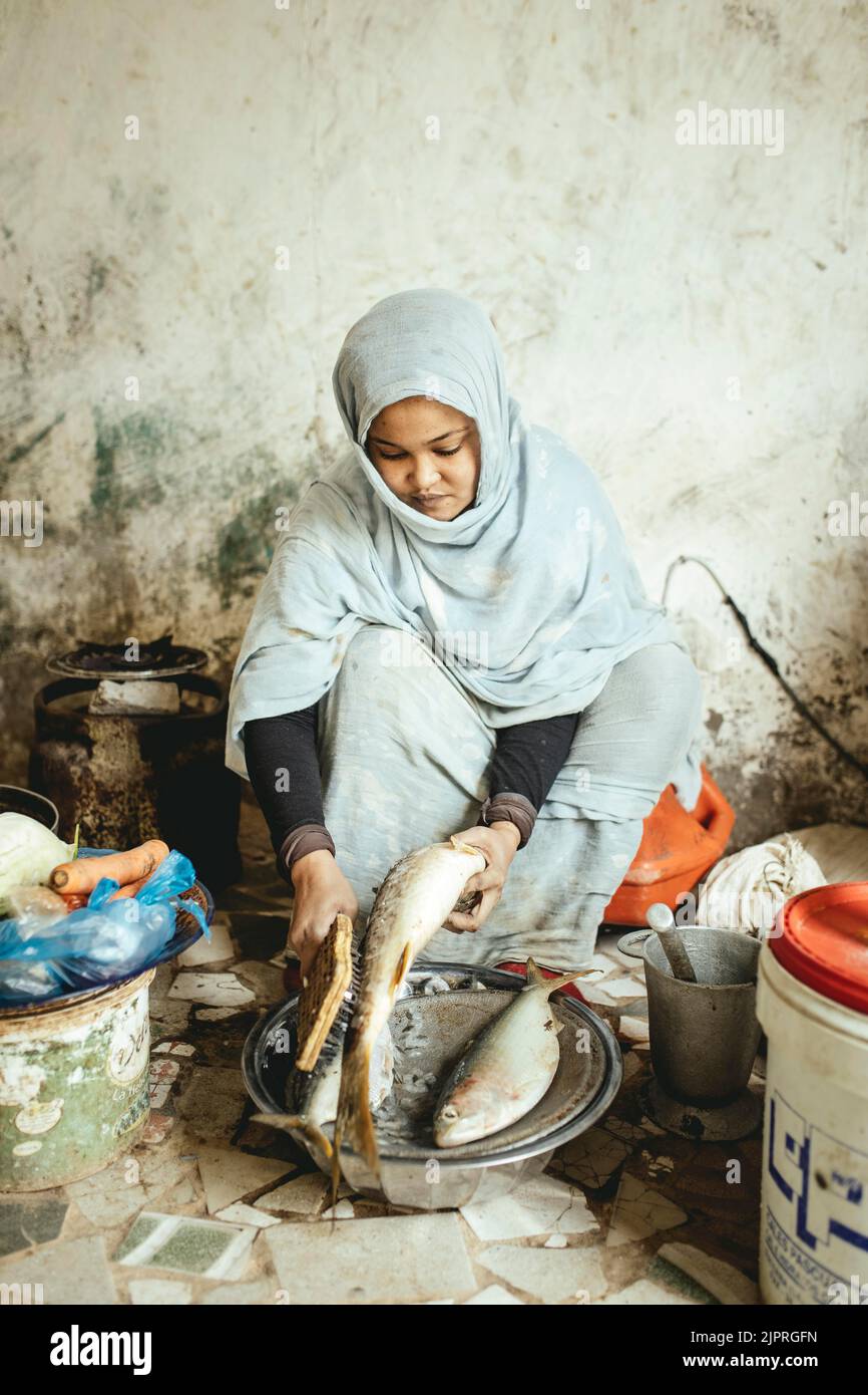 Ebeti Abidino, figlia del pescatore ben Abden che prepara cibo per la famiglia, riso con pesce, il piatto tradizionale dei pescatori e. Foto Stock