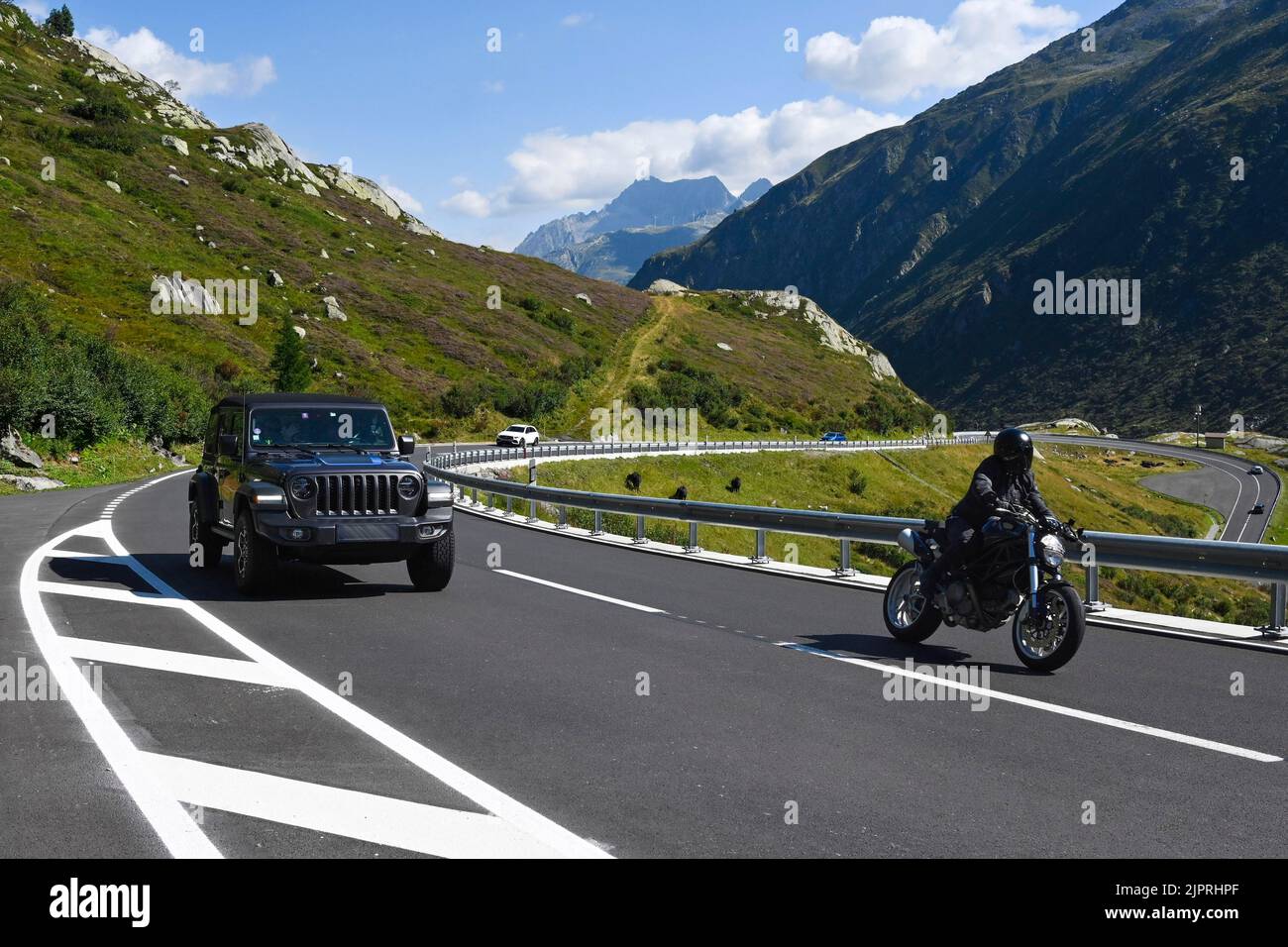 Il motociclista Gotthard Pass sorpassa l'automobile, in Svizzera Foto Stock