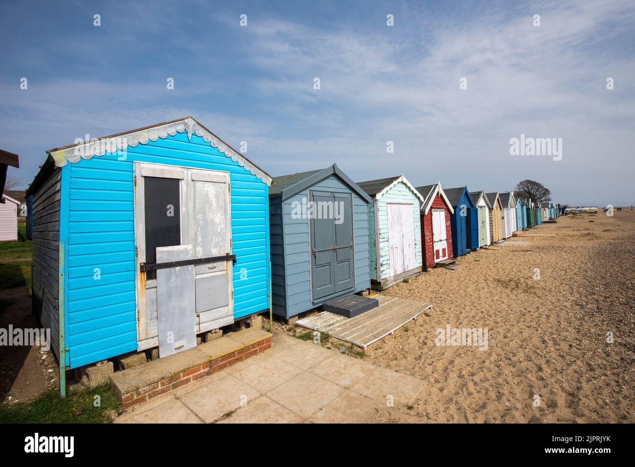 Vista frontale di una fila di capanne sulla spiaggia a Frinton on Sea nell'Essex UK Foto Stock