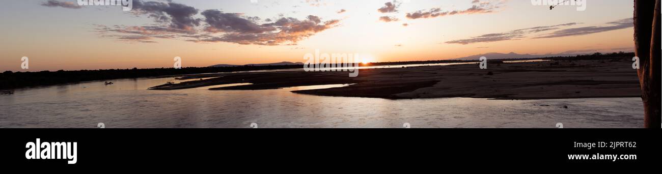 Il sole tramonta alla fine di una giornata di safari nel Parco Nazionale di Nyerere. Le crociere al tramonto sono una rilassante e spettacolare fine giornata. Foto Stock