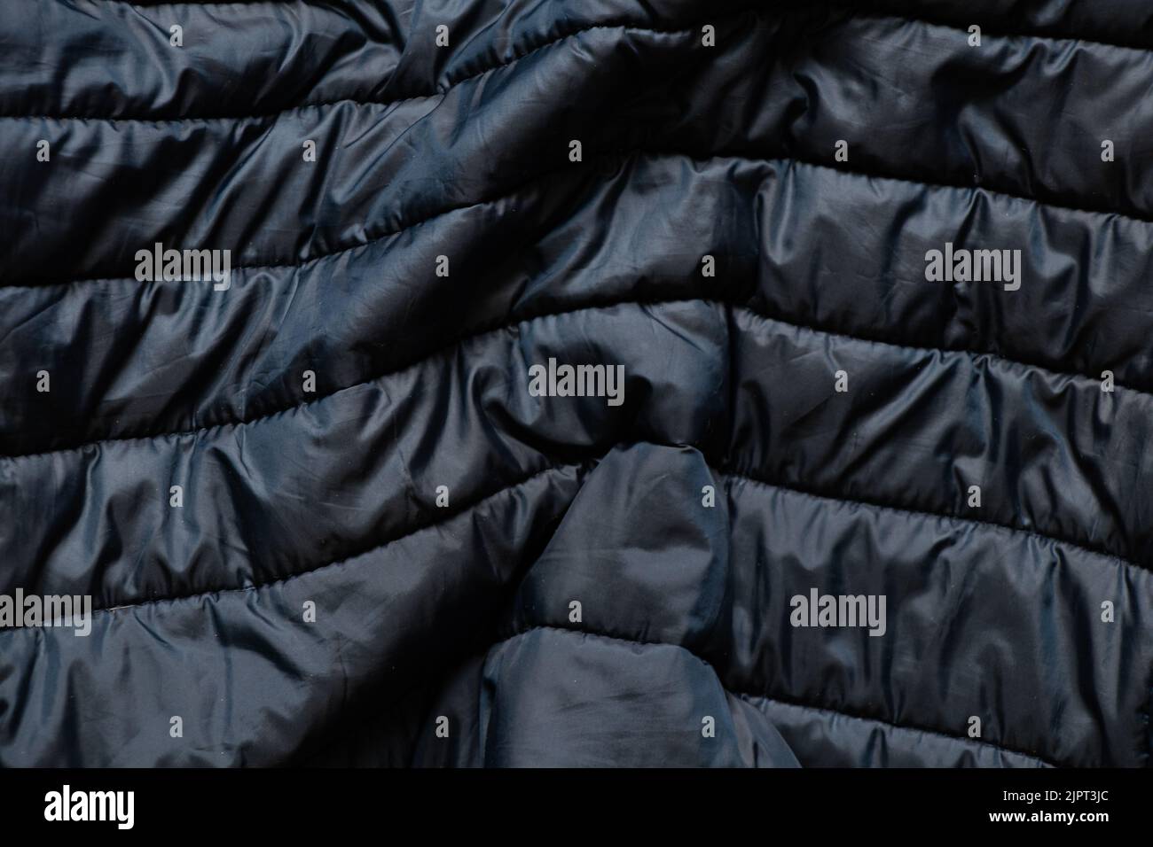 tessuto blu in giù di una giacca invernale da uomo come sfondo, tessuto blu, una giacca invernale come sfondo, outerwear, giacca Foto Stock