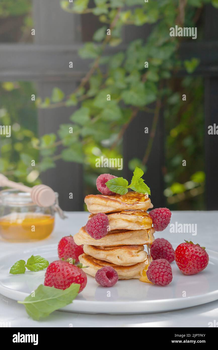 Frittelle con frutti di bosco sul tavolo. Colazione sana. Foto Stock