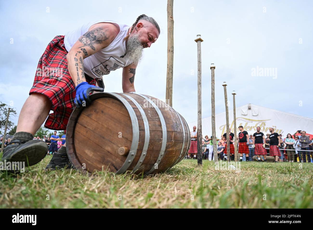 Wilhelmskirch, Germania. 20th ago, 2022. René Schulze della squadra Highländer di Engelberg tira un barile attraverso un corso di slalom al 'Oberschwäbische Highländgames'. Squadre provenienti da tutta la Germania meridionale si sono incontrate per mettere alla prova la loro abilità durante le partite. Credit: Felix Kästle/dpa/Alamy Live News Foto Stock