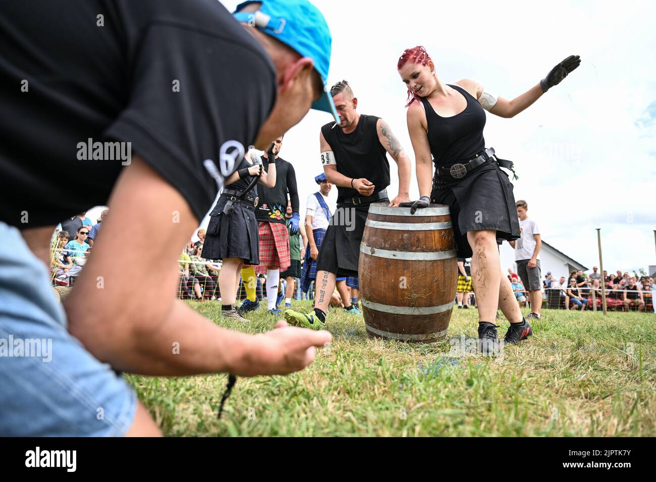 Wilhelmskirch, Germania. 20th ago, 2022. Jessica Jöst posiziona un barile al traguardo del 'Oberschwäbische Highländgames' dopo averlo fatto rotolare attraverso un percorso di slalom. Squadre provenienti da tutta la Germania meridionale si sono incontrate per mettere alla prova la loro abilità durante le partite. Credit: Felix Kästle/dpa/Alamy Live News Foto Stock