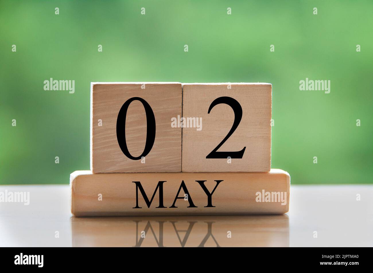 Maggio 2 calendario data testo su blocchi di legno con sfondo sfocato natura. Concetto di spazio di copia e calendario. Foto Stock