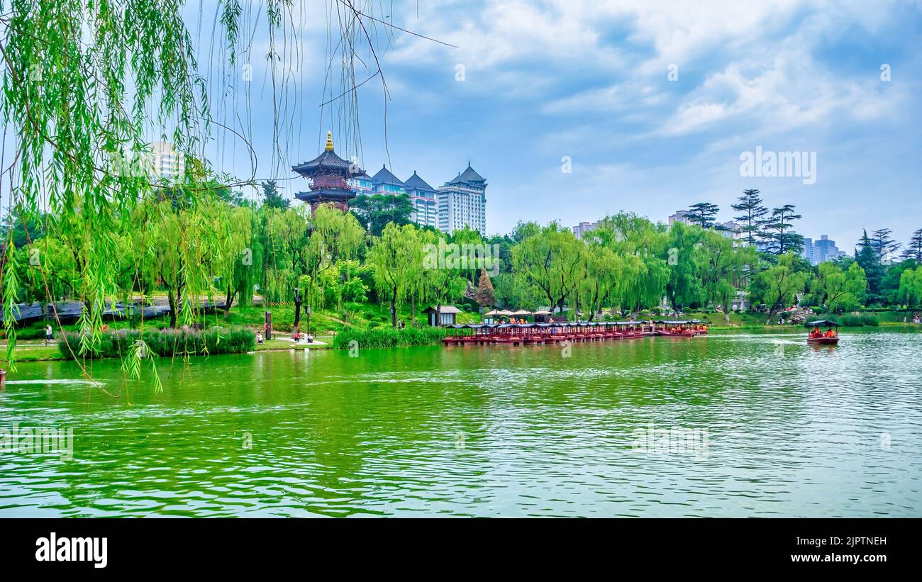 Furong Lake presso il Tang Paradise. Ampio angolo del paesaggio urbano e del parco pubblico. E' presente un molo con veicoli ad acqua a noleggio Foto Stock