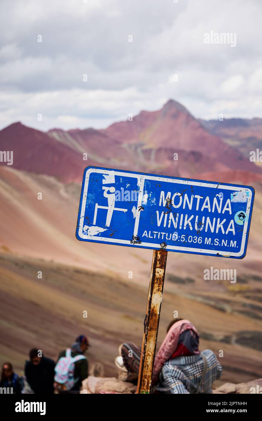 Un'immagine verticale di segnaletica su un palo arrugginito a Rainbow Mountain a Vinicunca, Cusco, Perù Foto Stock