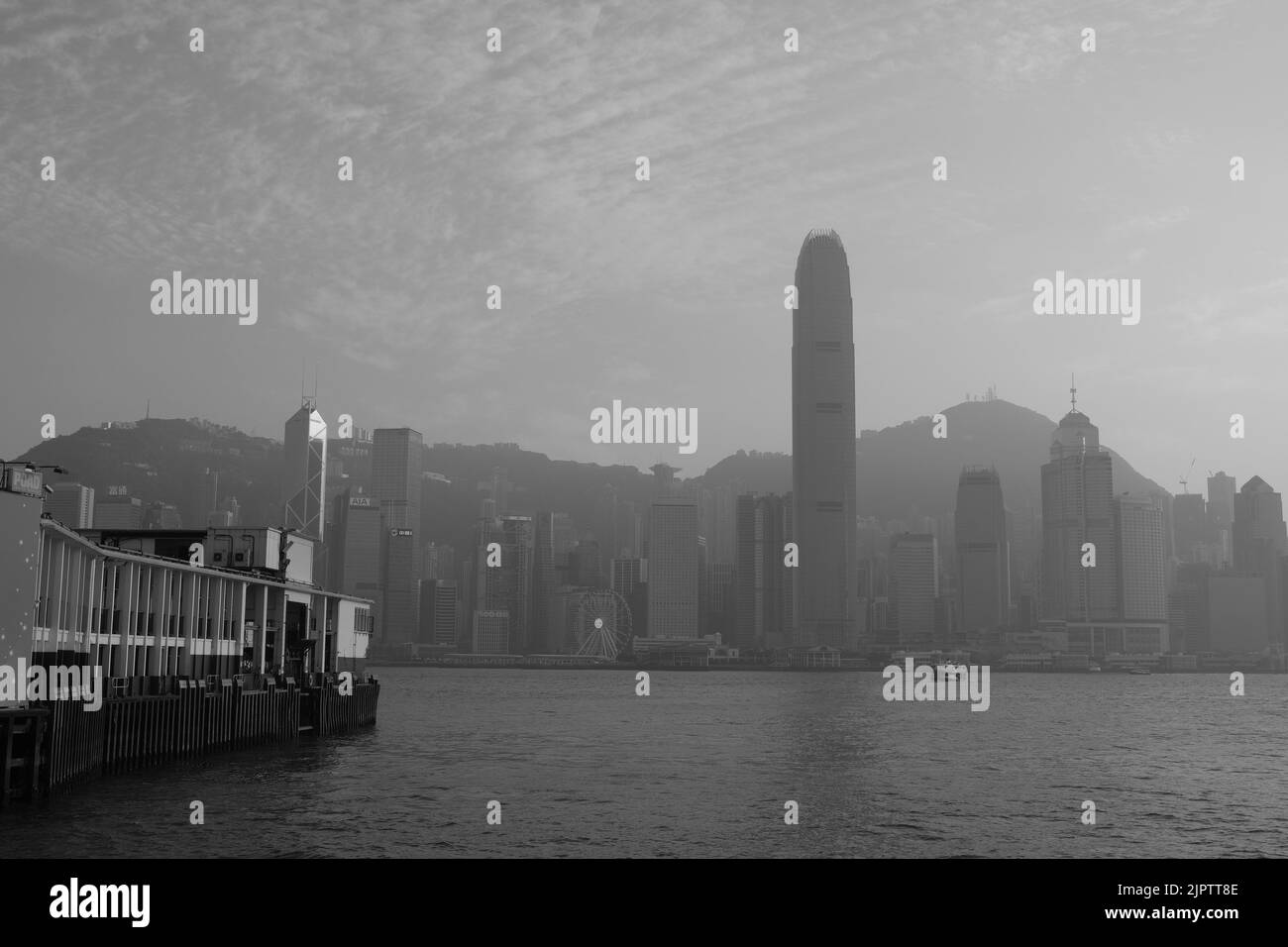 Star Ferry Pier a Tsim Sha Tsui Hong Kong Black White Photo Coloured Star Ferry Green White sfondo del traghetto è il centro di Hong Kong Island IFC Foto Stock