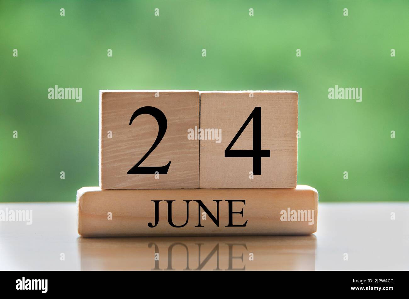 Giugno 24 calendario data testo su blocchi di legno con sfondo sfocato natura. Concetto di spazio di copia e calendario. Foto Stock