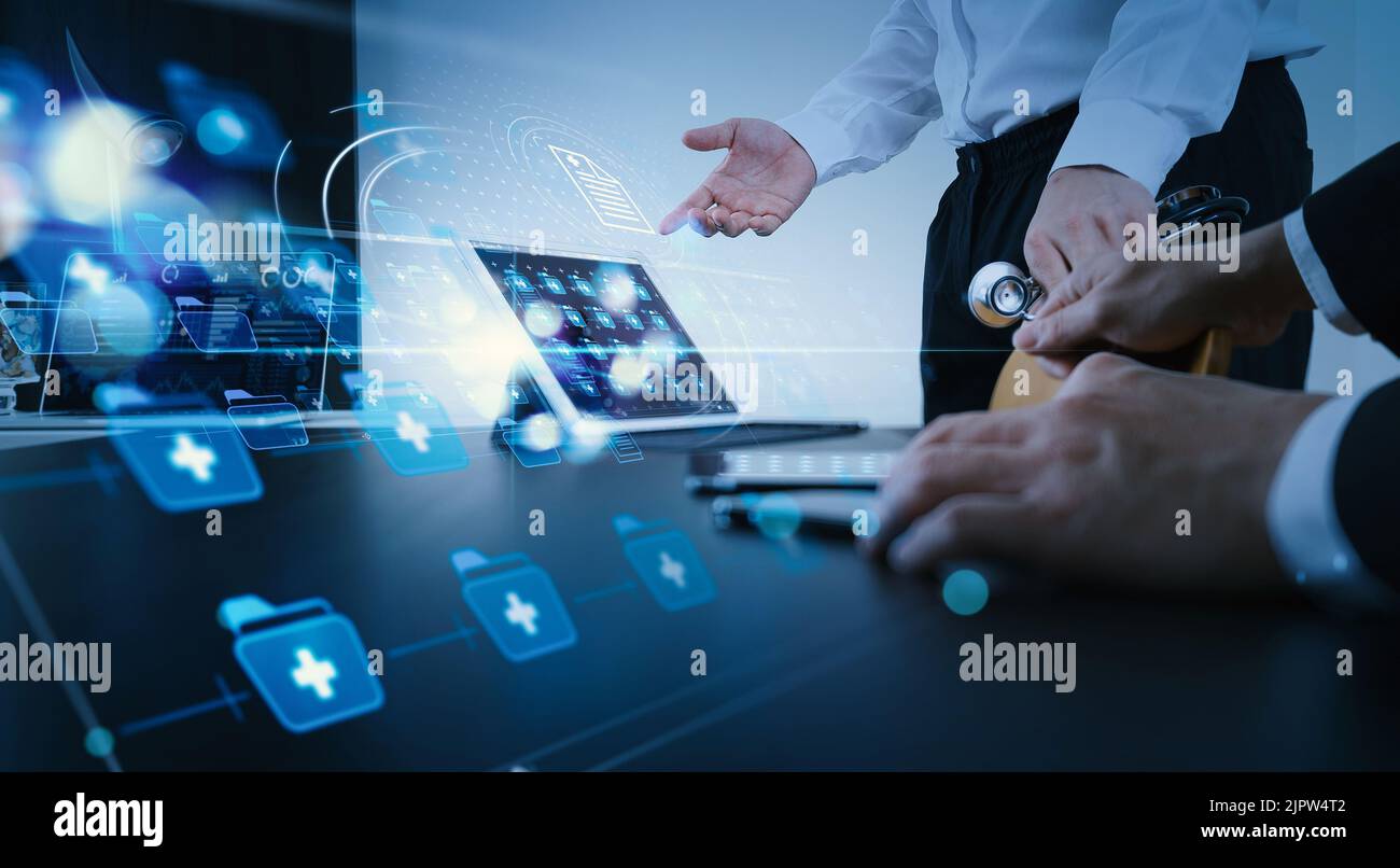 Concetto di co-working per la gestione dei dati medici, dottore che lavora con smartphone e tablet digitali e computer portatile per incontrare il suo team in un ufficio moderno Foto Stock