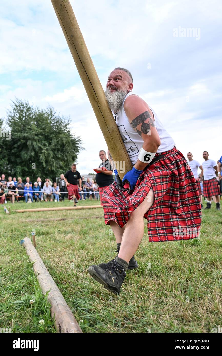 Wilhelmskirch, Germania. 20th ago, 2022. René Schulze del team Highländer di Engelberg lancia un tronco d'albero in aria al 'Oberschwäbische Highländgames' in modo che si ribalta. Squadre provenienti da tutta la Germania meridionale si sono incontrate per competere nei giochi. Credit: Felix Kästle/dpa/Alamy Live News Foto Stock