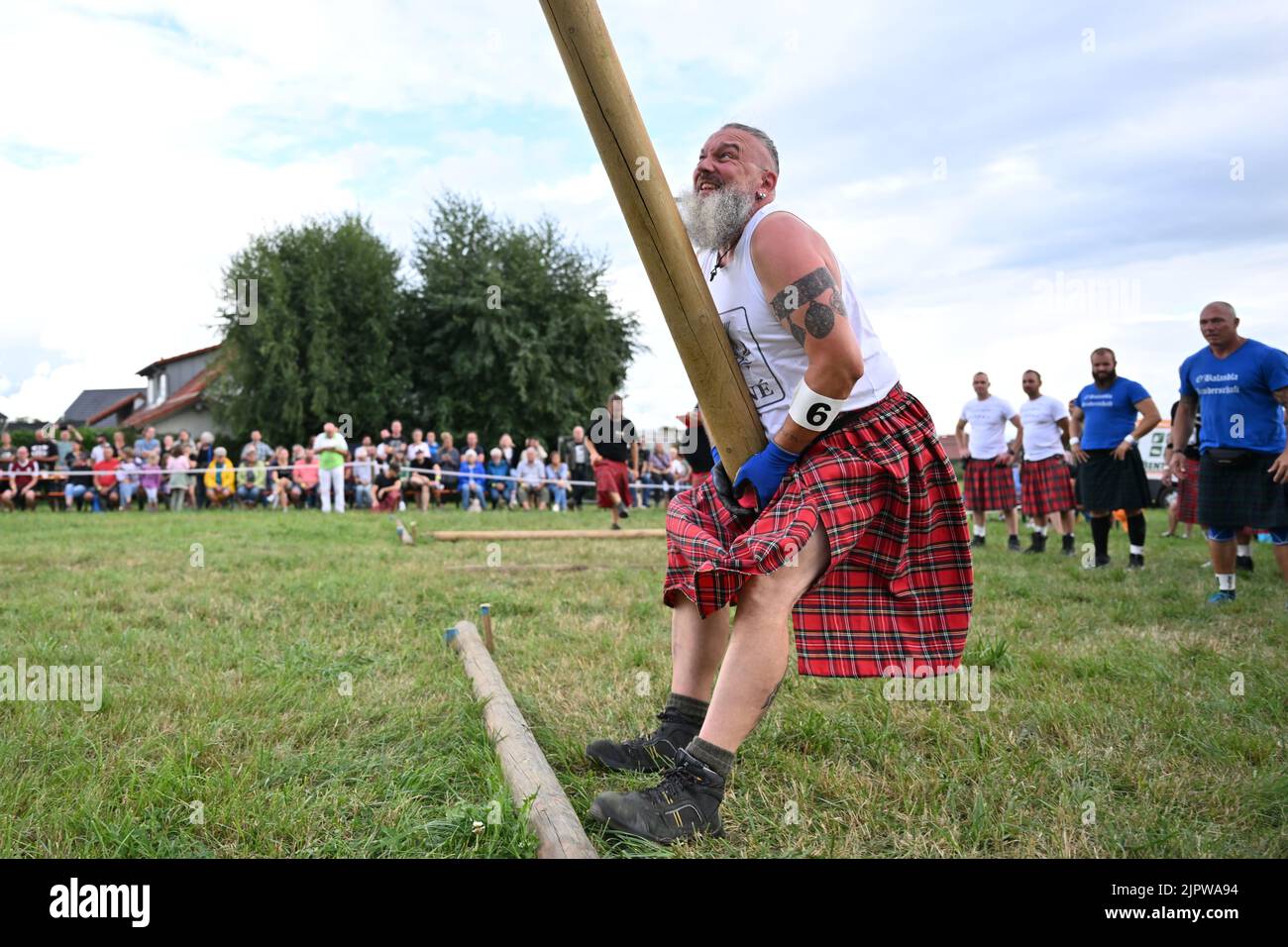 Wilhelmskirch, Germania. 20th ago, 2022. René Schulze del team Highländer di Engelberg lancia un tronco d'albero in aria al 'Oberschwäbische Highländgames' in modo che si ribalta. Squadre provenienti da tutta la Germania meridionale si sono incontrate per competere nei giochi. Credit: Felix Kästle/dpa/Alamy Live News Foto Stock