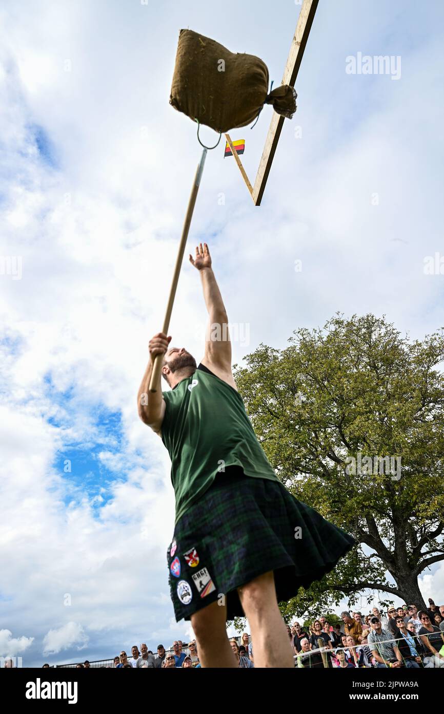 Wilhelmskirch, Germania. 20th ago, 2022. Un partecipante lancia un sacco di paglia su un fascio alto circa sette metri al 'Oberschwäbische Highländgames'. Il cosiddetto 'Sheaf toss' è una disciplina dei Giochi delle Highland. Squadre provenienti da tutta la Germania meridionale si sono incontrate per competere nei giochi. Credit: Felix Kästle/dpa/Alamy Live News Foto Stock