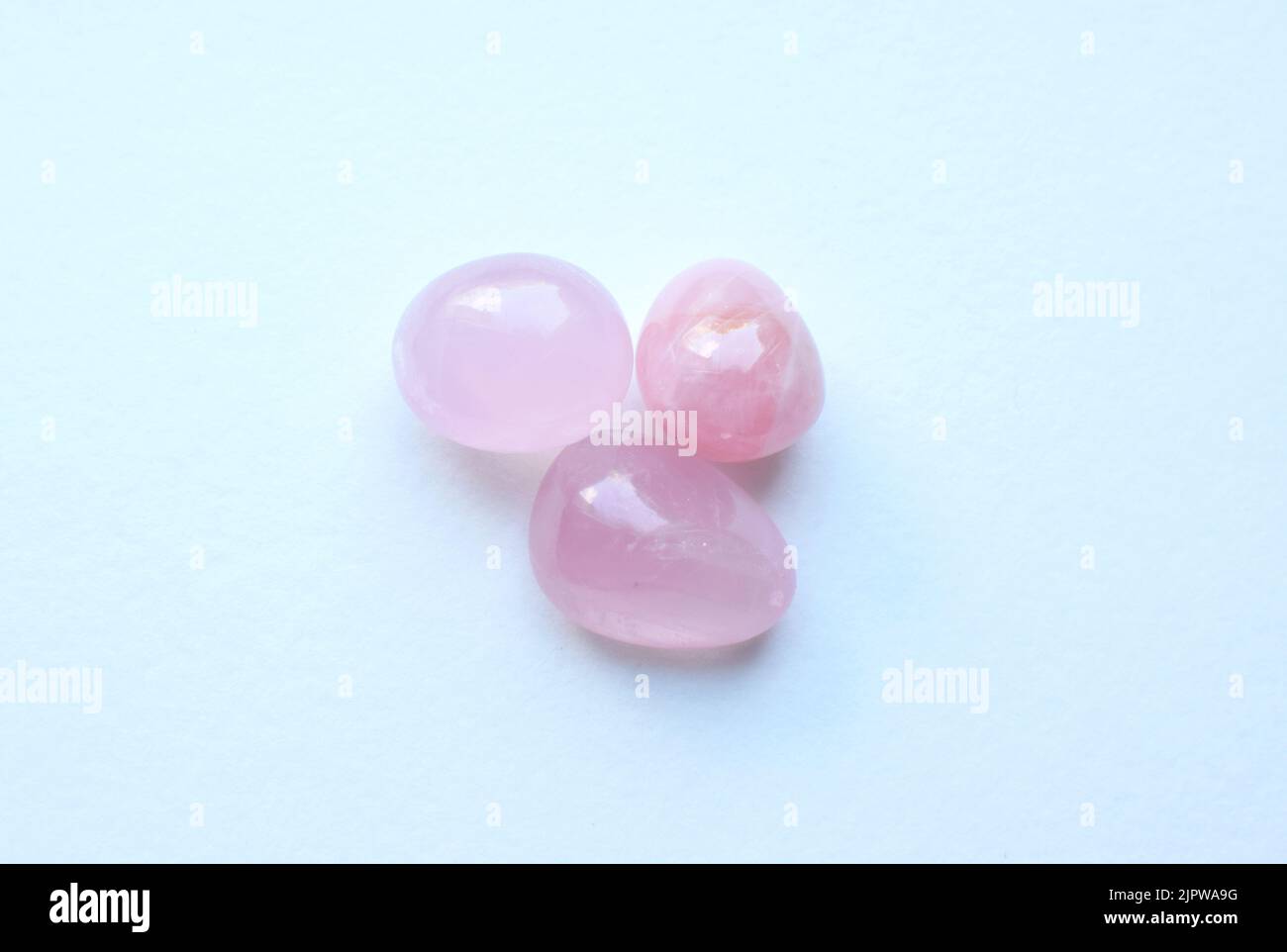 Tre pietre di quarzo rosa tumbled. I cristalli semi-preziosi di quarzo rosa sono un talismano d'amore per le donne. Foto Stock