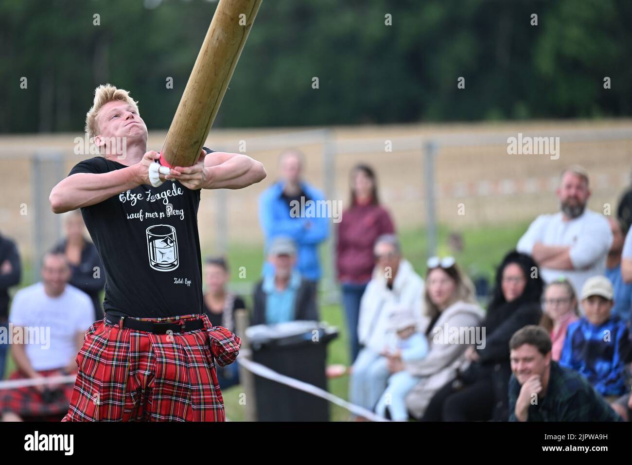 Wilhelmskirch, Germania. 20th ago, 2022. Niklas Müller getta un tronco d'albero nell'aria al 'Oberschwäbische Highländgames' in modo che si ribalta. Squadre provenienti da tutta la Germania meridionale si sono incontrate per mettere alla prova la loro abilità nei giochi. Credit: Felix Kästle/dpa/Alamy Live News Foto Stock