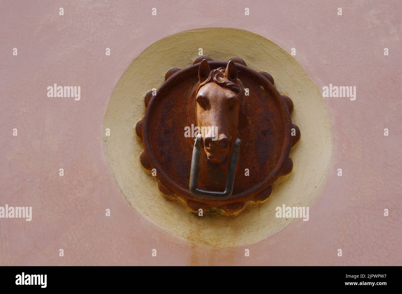 Antico ornamento di ferro per legare cavalli o animali da tiro alle pareti degli edifici Foto Stock