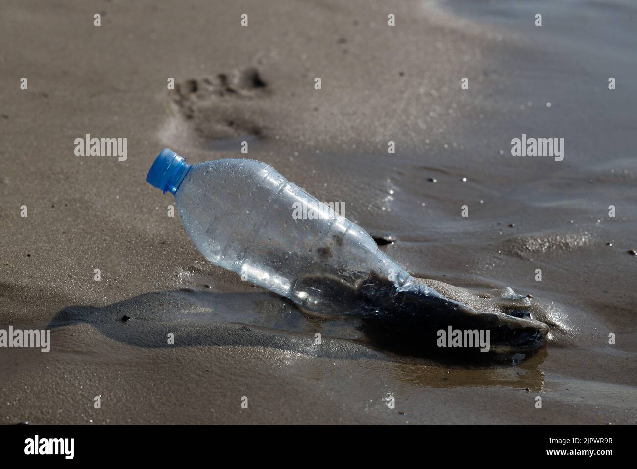 Bottiglia blu di plastica sulla costa del mare, ecosistema senza inquinamento pianeta SAVE concetto Foto Stock