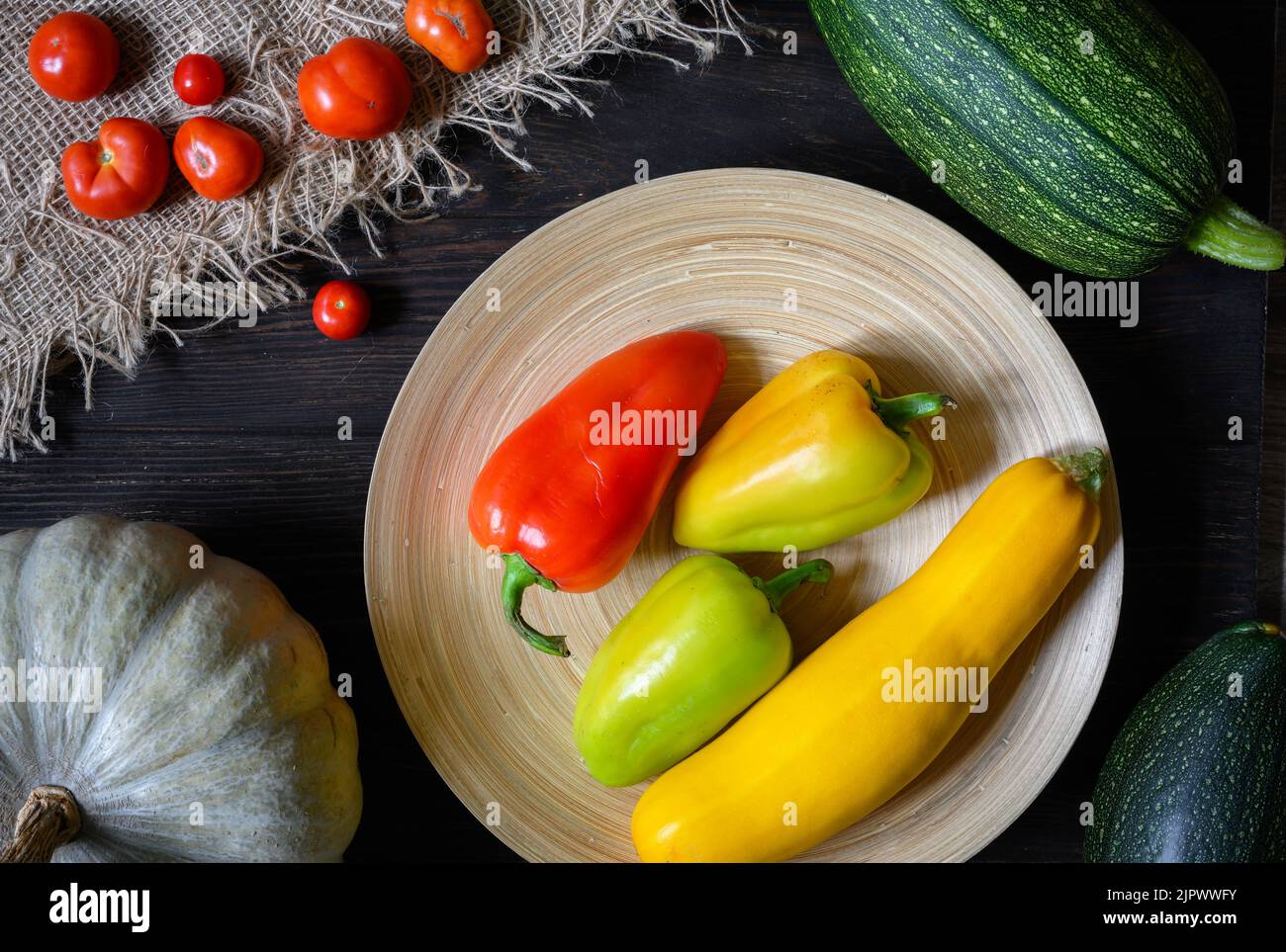 Midollo vegetale e pepe dolce su tavola di legno, piatto. Vista dall'alto di zucchine fresche, zucca e pomodori in cucina, set di cibi biologici. Concetto o Foto Stock
