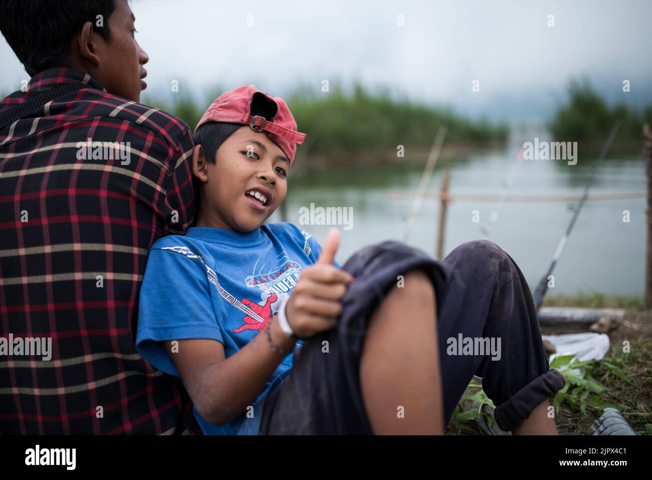 UBUD, BALI, INDONESIA, 15 MAGGIO 2017; Ritratto di ragazzo e suo padre pesca da Beratan lago. Immagine indonesiana del ragazzo. Foto Stock