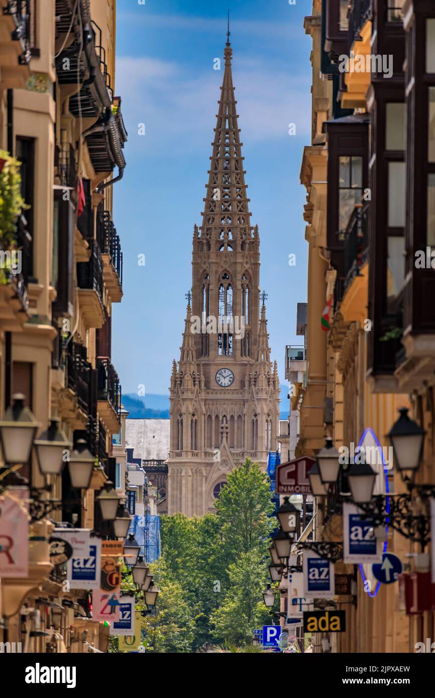 San Sebastian, Spagna - 25 giugno 2021: Vista lungo una strada nella città vecchia su buon Pastore della cattedrale di San Sebastian in rinascita gotica con 75 m di guglia Foto Stock