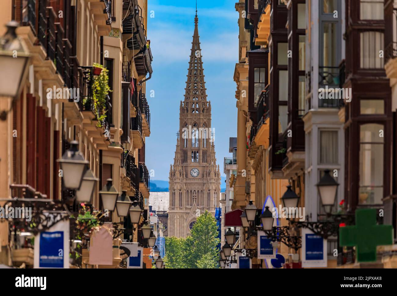 Vista lungo una strada nella città vecchia su buon Pastore di San Sebastian cattedrale in rinascita gotica con una guglia di 75 m a Donostia, Paesi Baschi, Spagna Foto Stock
